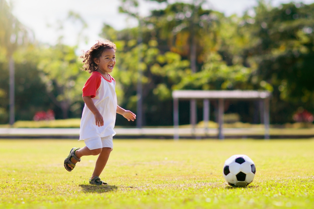 Child playing soccer outside